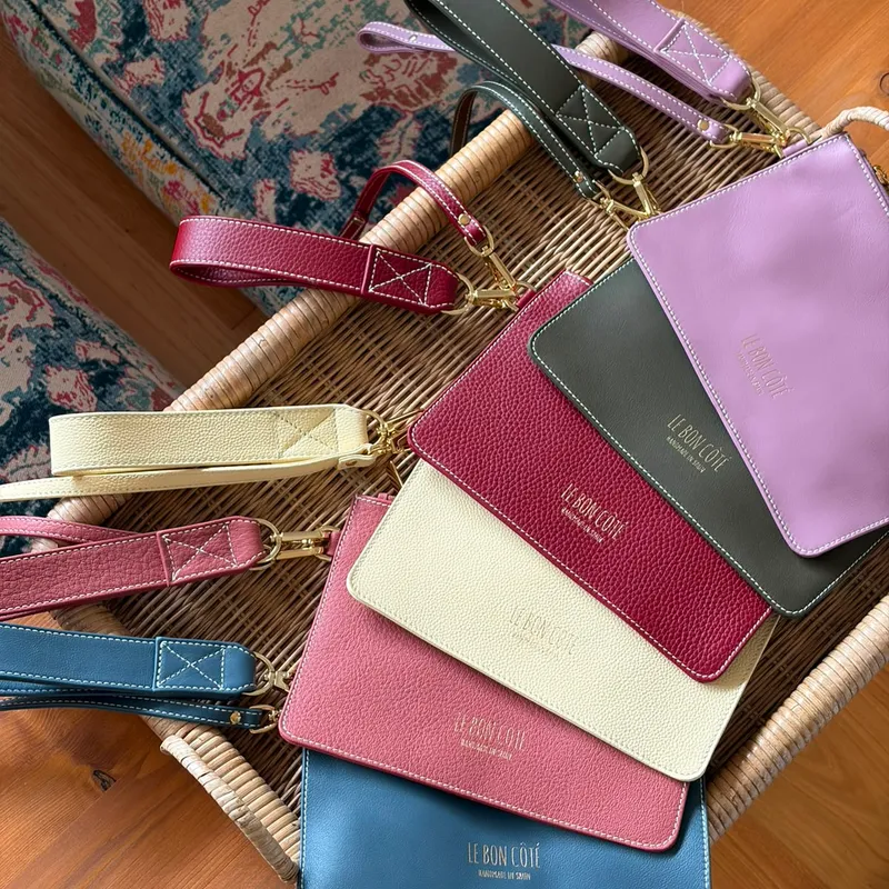 Carteras Domitila en seis tonos de piel sobre una cesta de mimbre